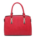 Front view of a red grab bag with twin top handles and decorative metal fittings