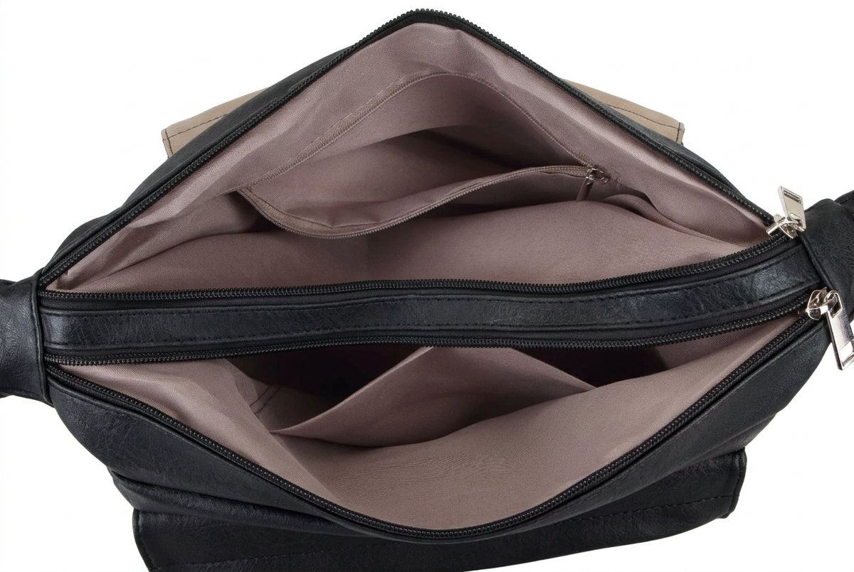 Open view of a black faux leather bag showing the interior lining and multiple zip compartments against a white background.