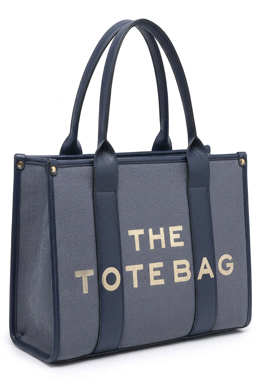A navy blue tote bag with a textured gray body and gold lettering that reads 'THE TOTE BAG' on the front, set against a plain white background.
