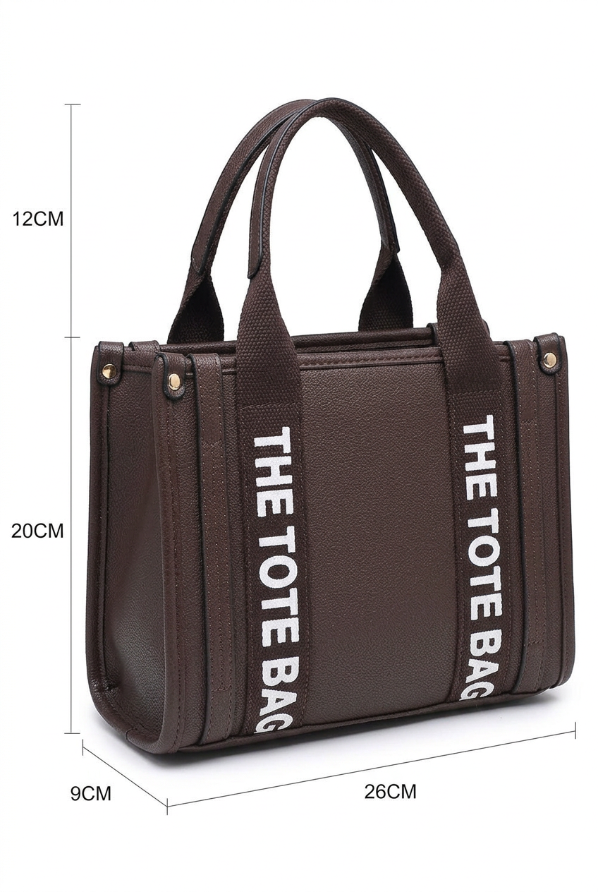 A dark brown tote bag with dual top handles and vertical white text reading 'THE TOTE BAG' on the sides, shown with dimension lines indicating 9cm width, 26cm depth, 12cm handle height, and 20cm total height on a white background.