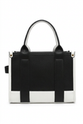 A structured black and white handbag with double top handles, a top zipper closure, and a small black side tag, shown against a plain white background.
