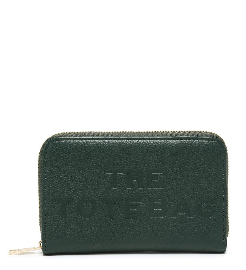 A dark green pebbled zip-around wallet with 'THE TOTE BAG' embossed on the front, shown against a plain white background.