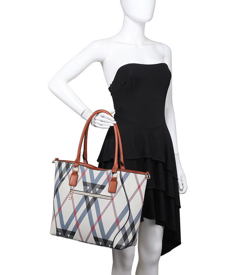 A tote bag with a plaid pattern in beige, navy, and red, featuring brown handles, held by a white mannequin wearing a black strapless dress against a white background.