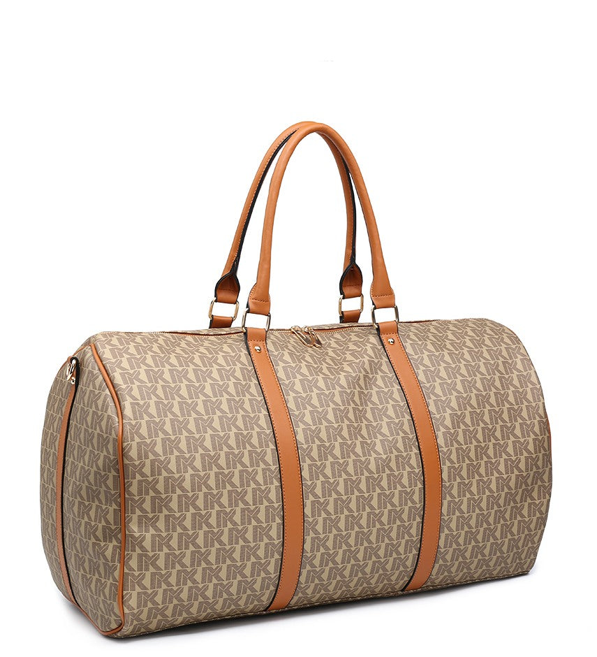 A cylindrical duffel bag with a beige and brown repeating monogram pattern, featuring tan handles and trim, photographed on a solid white background.
