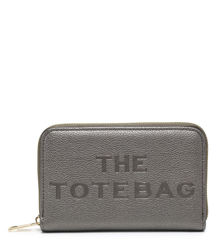A gray pebbled zip-around wallet with 'THE TOTE BAG' embossed on the front, shown on a plain white background.
