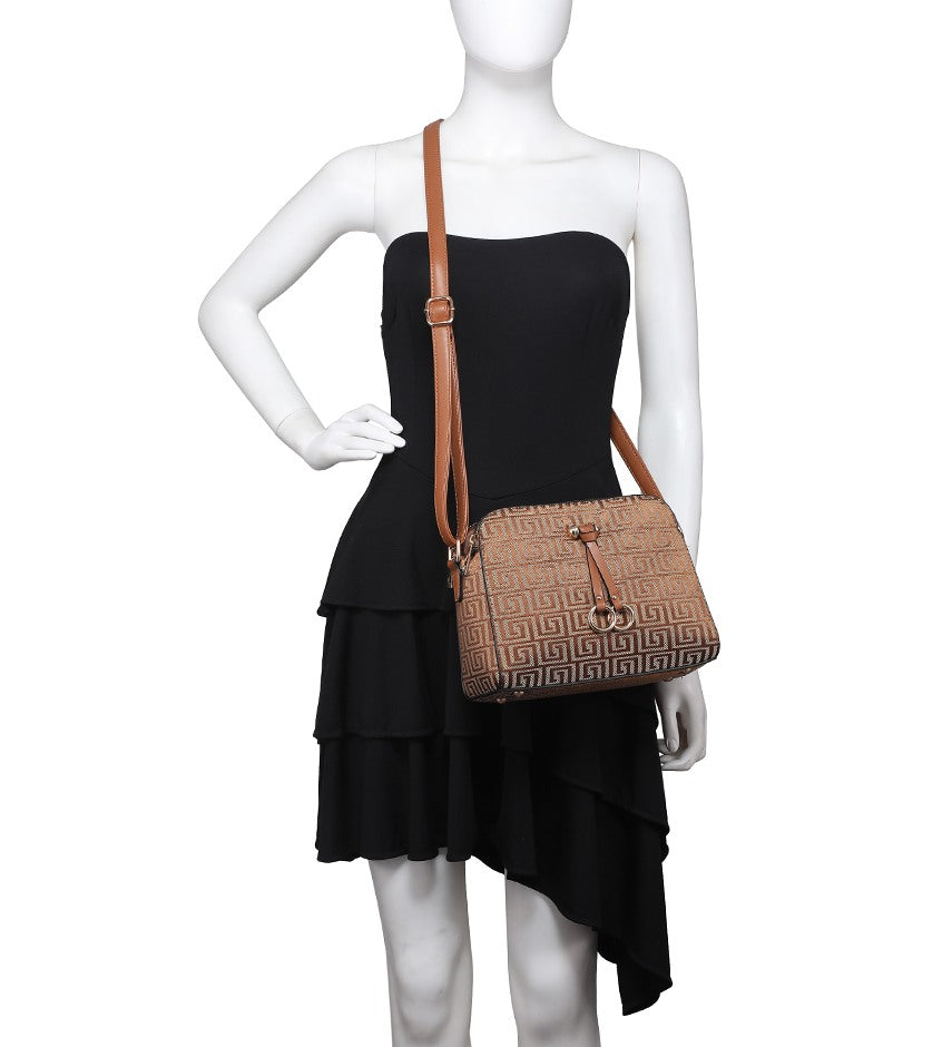 A brown shoulder bag with an embossed Greek key pattern and a gold-tone horsebit detail, displayed on a white mannequin wearing a black strapless dress.