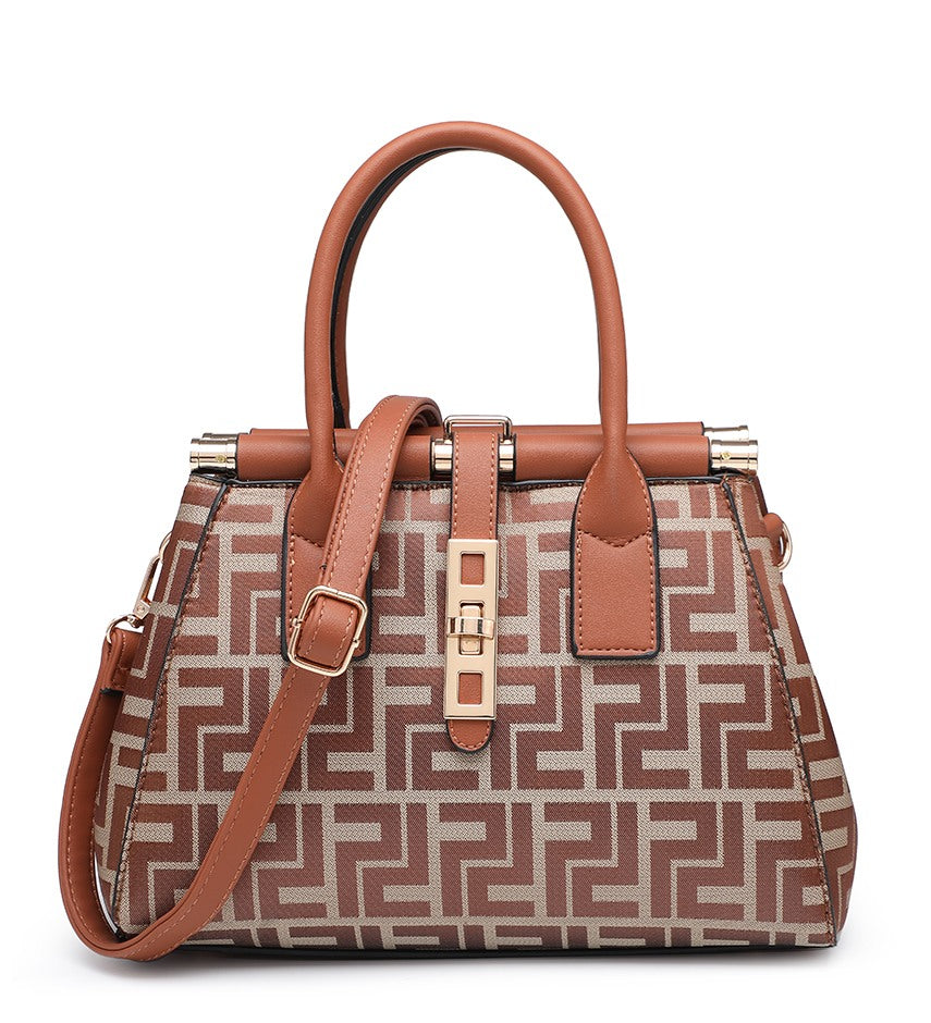 A structured handbag with a brown and beige geometric patterned body, tan handles and trim, and gold-tone hardware, shown on a plain white background.