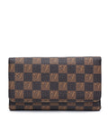 A long wallet in the classic Damier Ebene checkered pattern, featuring alternating brown and dark brown squares with embossed V logos, shown against a plain white background.